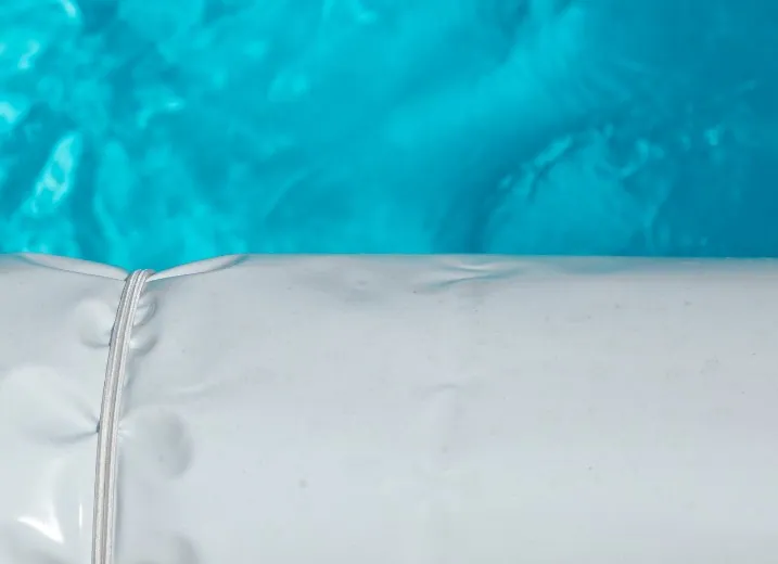 Cubierta de PVC blanca para piscina Detalle de cubierta de PVC blanca flotando sobre el agua de una piscina