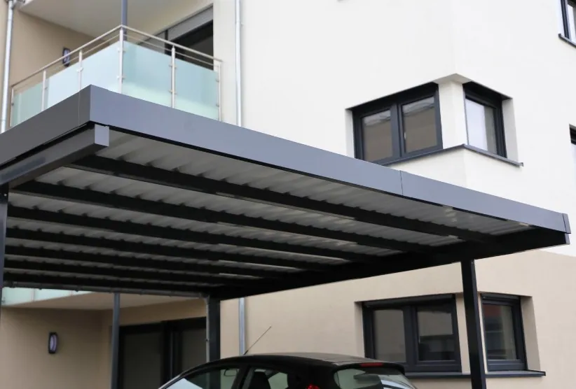 Marquesina de aluminio con lamas sobre garaje Marquesina fija de aluminio con lamas adosada a la fachada sobre una plaza de aparcamiento