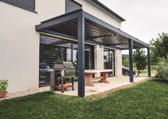 Pérgola bioclimática antracita adosada Pérgola bioclimática antracita adosada a una vivienda con comedor exterior