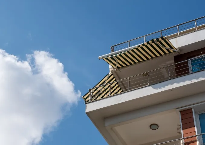 Toldo cofre con lona de rayas instalado en la terraza de un ático en Murcia
