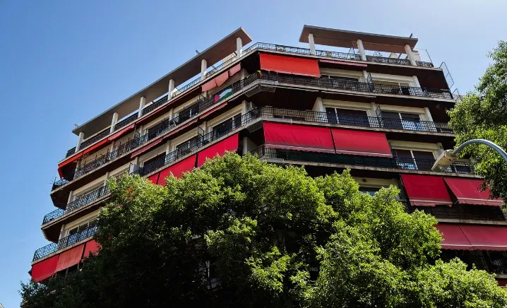 Edificio residencial con toldos rojos de brazos en todos los balcones