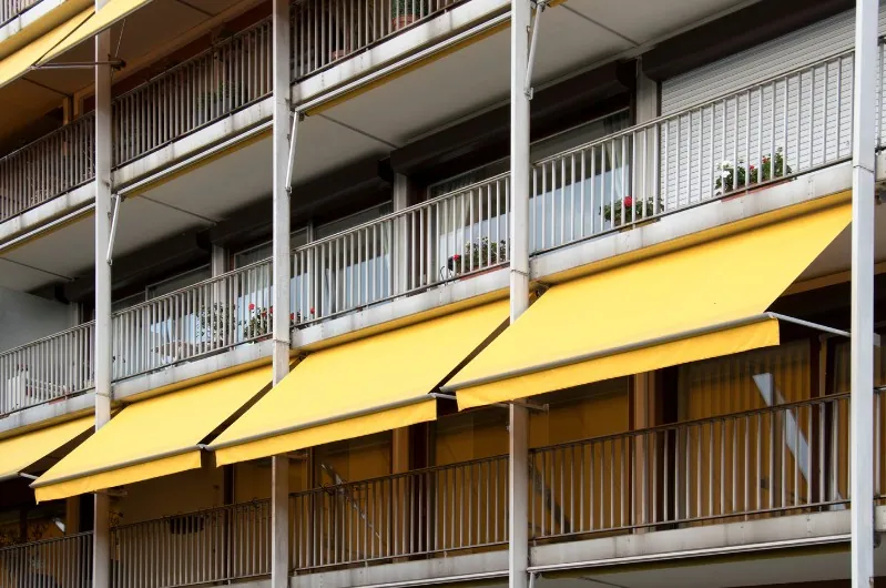 Toldos stor amarillos en balcones Edificio de viviendas con toldos stor amarillos en todos los balcones